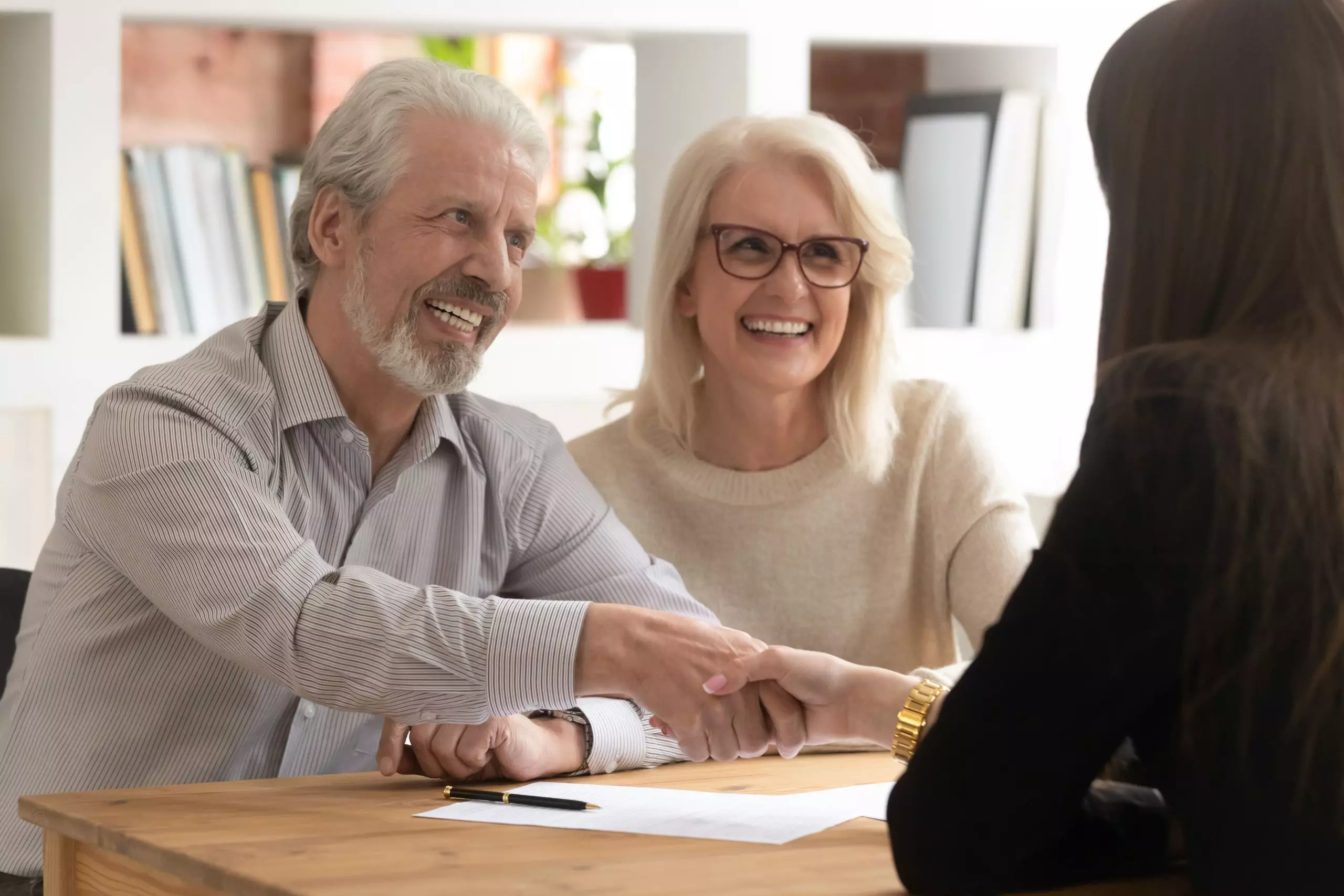 Estate agent shaking hands with his customer after contract signature